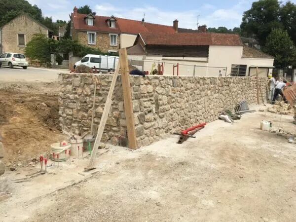 Construction d'un mur de soutènement en pierres.